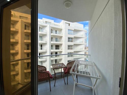 Un balcón con sillas y una mesa y un edificio. en Scandic resort, en Hurghada