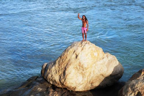 a woman standing on a rock in the water at Orchard House Galle in Galle