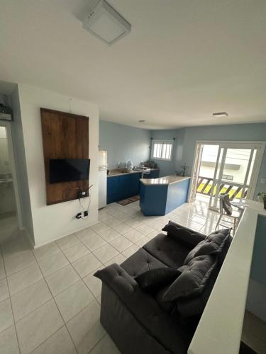 a living room with a couch and a kitchen at Apartamento 4 quadras do mar! in Xangri-lá