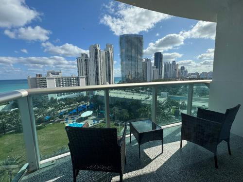 a balcony with chairs and a view of the city at Luxury Ocean Reserve Condo Pool, Gym & Beach Access in Sunny Isles Beach