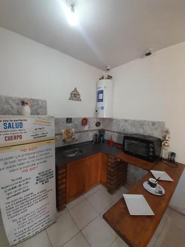 a kitchen with a table and a sink and a microwave at Complejo Don Tito in San Juan
