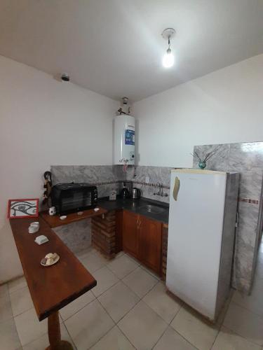 a kitchen with a refrigerator and a table in it at Complejo Don Tito in San Juan