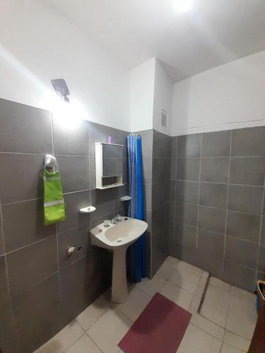 a small bathroom with a sink and a mirror at Complejo Don Tito in San Juan