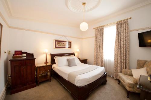 Postel nebo postele na pokoji v ubytování Cobb & Co Court Boutique Hotel