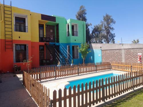 a house with a pool in front of a fence at Complejo Don Tito in San Juan