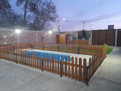a wooden fence with a pool in front of a building at Complejo Don Tito in San Juan