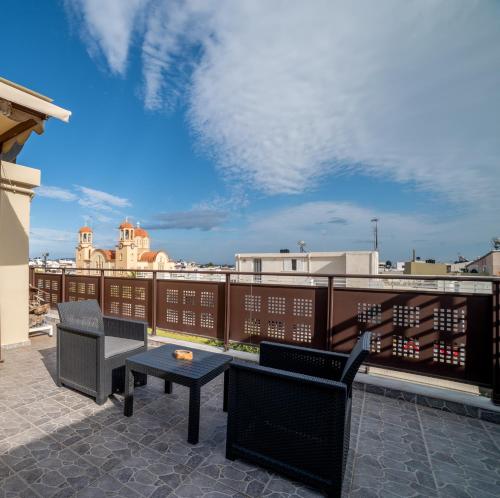 a patio with two chairs and a table on a roof at Filotimo RoofGarden Green Apt in Heraklion