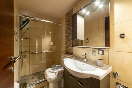 a bathroom with a sink and a toilet and a shower at Filotimo RoofGarden Green Apt in Heraklion