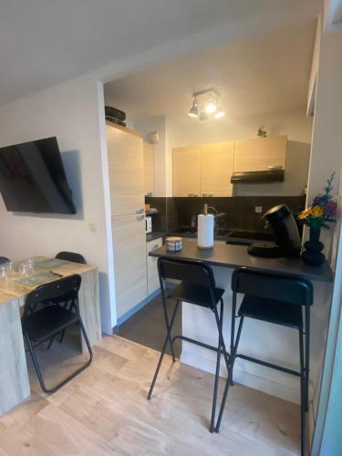 une petite cuisine avec une table et deux chaises dans l'établissement Studio cabine Cannes la Bocca, à Cannes