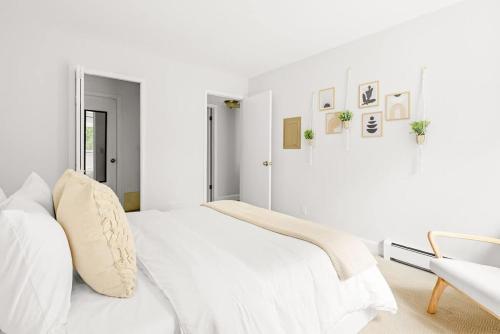 a white bedroom with a white bed and a chair at Bright & Modern - King Suite - Creekside Trail in Boulder