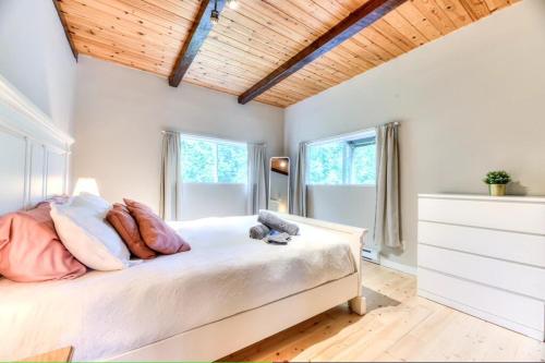 a bedroom with a bed with pillows and a wooden ceiling at Chalet Ruby Rouge in Chertsey