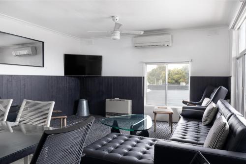 a living room with a couch and chairs at Siesta Central Apartments in Sale