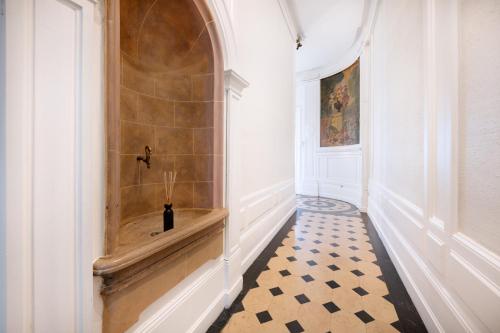 un couloir avec du carrelage et un mur avec une niche dans l'établissement Le Rhône Haussmannien, Luxueux spacieux et raffiné au cœur de Lyon 6e vue Rhône, à Lyon