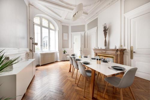 une salle à manger blanche avec une table et des chaises dans l'établissement Le Rhône Haussmannien, Luxueux spacieux et raffiné au cœur de Lyon 6e vue Rhône, à Lyon