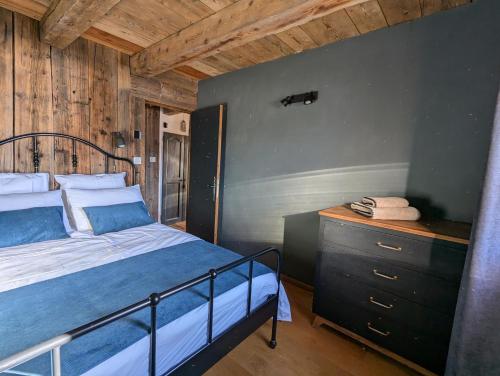 une chambre avec un lit et un mur en bois dans l'établissement Grange 1767 - vue imprenable - proche SAMOËNS/MORRILON, à Verchaix