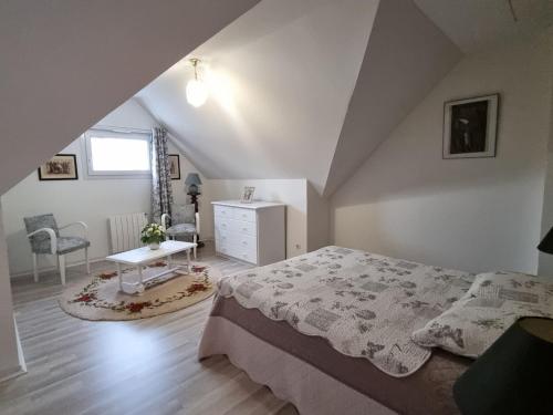 ein Schlafzimmer mit einem Bett und einem Schreibtisch auf einem Dachboden in der Unterkunft Appartement T3 Duplex, 4 Pers, Centre Sarzeau, Balcon - FR-1-775-18 in Sarzeau