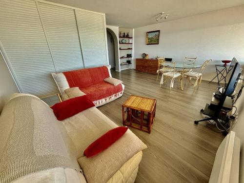 un salon avec un canapé et une table dans l'établissement Appartement en front de mer au Lavandou avec vue panoramique - FR-1-816-16, au Lavandou