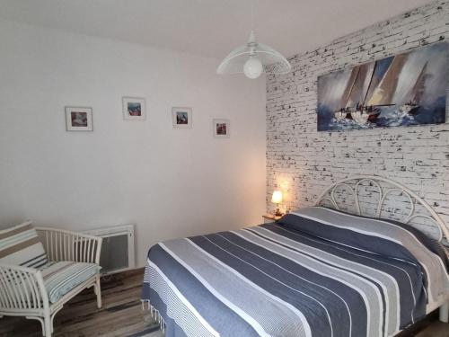 - une chambre avec un lit et un mur en briques blanches dans l'établissement Maison au calme avec jardin, 3 chambres, plage et commerces à proximité, WiFi, animaux acceptés - FR-1-775-20, à Sarzeau