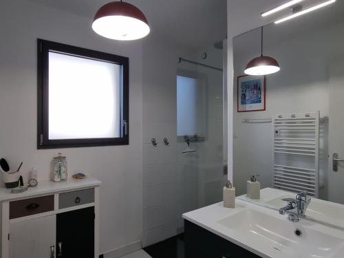 une salle de bain blanche avec un lavabo et une douche dans l'établissement Maison au calme avec jardin, 3 chambres, plage et commerces à proximité, WiFi, animaux acceptés - FR-1-775-20, à Sarzeau