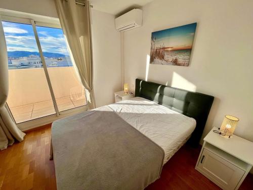 une chambre avec un lit et une grande fenêtre dans l'établissement Appartement avec piscine et terrasse, proche plage, climatisé, garage à Fréjus - FR-1-226A-184, à Fréjus
