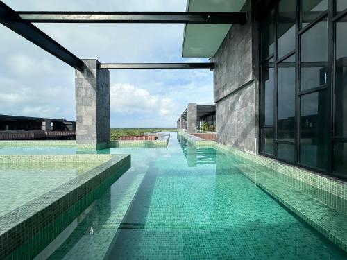a swimming pool with green water in a building at Stay Near The Sea HOTEL ZONE TULUM 1 Bedroom in Tulum