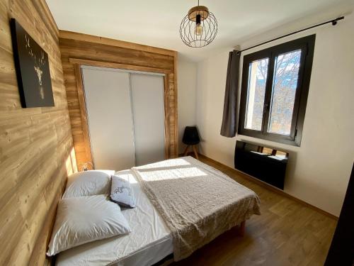 une chambre avec un lit et une fenêtre dans l'établissement Appartement T3 rénové avec 2 chambres, proche centre, parking, Formiguères - FR-1-758-37, à Formiguères