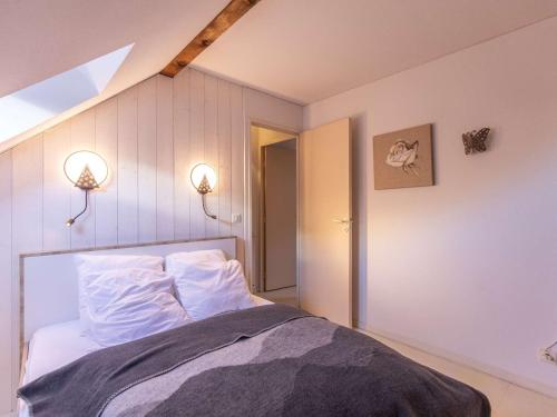 une chambre avec un lit avec des draps blancs et des oreillers dans l'établissement Duplex rénové T3 proche centre de Cauterets - FR-1-401-312, à Cauterets