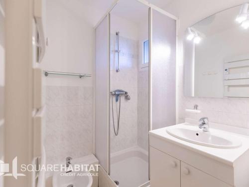 une salle de bain blanche avec une douche et un lavabo dans l'établissement Duplex rénové T3 proche centre de Cauterets - FR-1-401-312, à Cauterets