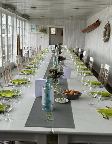 a long table in a room with chairs and glasses at Strandhaus Edersee Nr 12 - Kaminzimmer, Seeblick, Badestrand, Seeterrasse in Waldeck