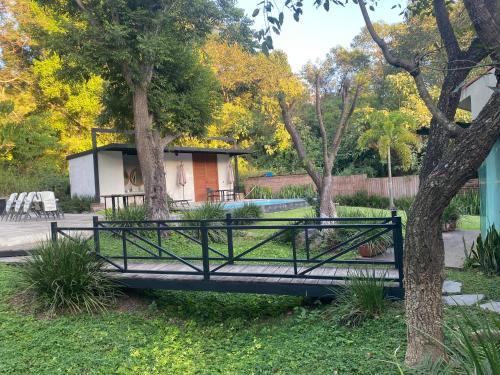 a black metal bridge in a park with trees at Casa NOGAL in Santa María del Oro