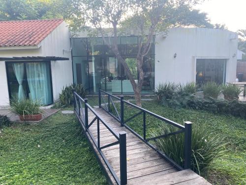 a wooden walkway leading to a white house at Casa NOGAL in Santa María del Oro