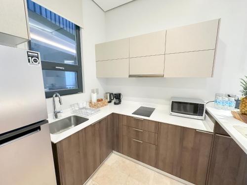 a kitchen with wooden cabinets and a sink and a window at Stay Near The Sea HOTEL ZONE TULUM 1 Bedroom in Tulum