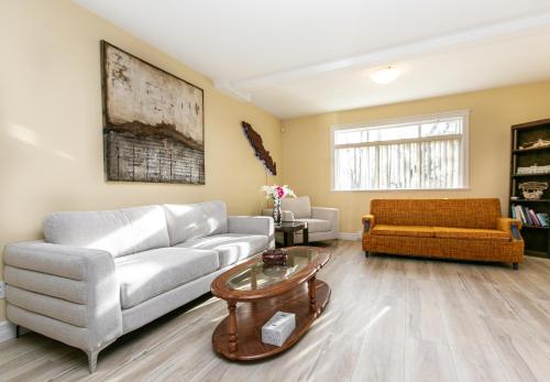 a living room with a couch and a table at 2 BR Spacious Ground Level Suite in Victoria