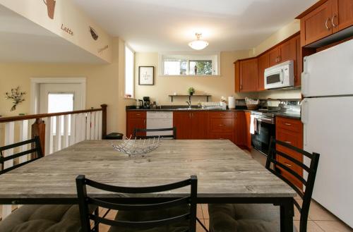 cocina con mesa de madera y nevera blanca en 2 BR Spacious Ground Level Suite, en Victoria