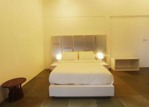 a bedroom with a white bed with two night stands at Harmony Valley Retreat in Bukit Tinggi