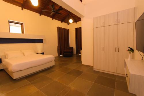 a bedroom with a white bed and a tiled floor at Harmony Valley Retreat in Bukit Tinggi