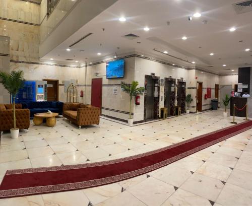 eine Lobby mit Sofas und einem TV in einem Gebäude in der Unterkunft ATYAF ALKHIR HOTEl in Mekka