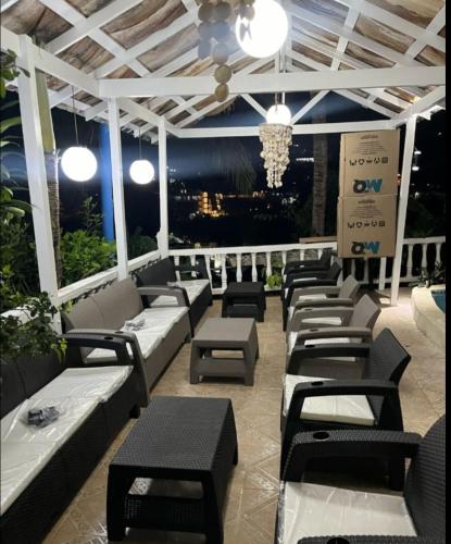a patio with couches and tables and a chandelier at BLUE HOUSE OCEAN VIEW in Santa Bárbara de Samaná