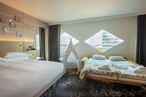 a hotel room with two beds and a window at Hilton Amsterdam Airport Schiphol in Schiphol