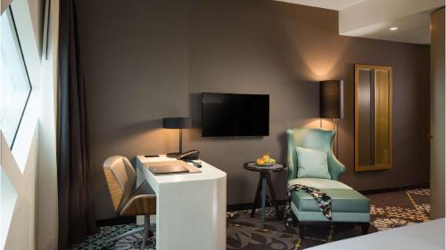 a hotel room with a desk and a chair at Hilton Amsterdam Airport Schiphol in Schiphol