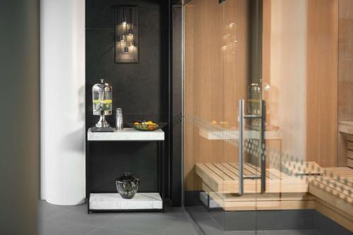 a room with a glass door with a table and a shelf at Hilton Amsterdam Airport Schiphol in Schiphol