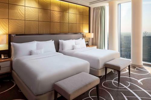 a hotel room with two beds and a window at Waldorf Astoria Berlin in Berlin