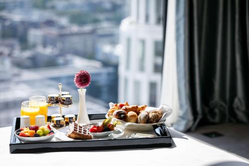 a tray of breakfast food on a table with a view at Waldorf Astoria Berlin in Berlin