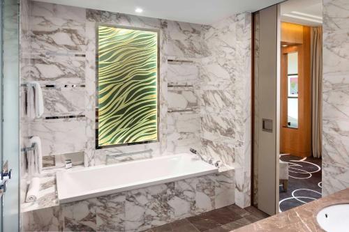 a bathroom with a bath tub and a window at Waldorf Astoria Berlin in Berlin
