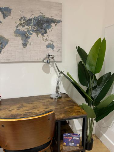 a desk with a lamp and a potted plant at Luxury Penthouse with Private Hot Tub Overlooking Leeds City Centre in Leeds