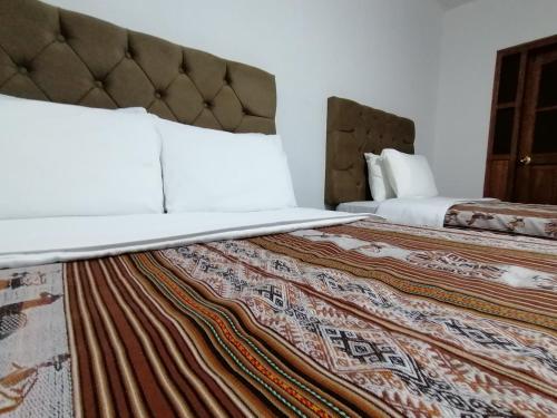 a hotel room with a bed with a laptop on it at Magnolia Andina in Cusco
