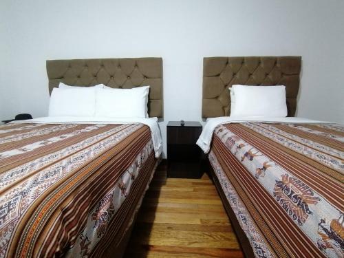 two beds sitting next to each other in a room at Magnolia Andina in Cusco
