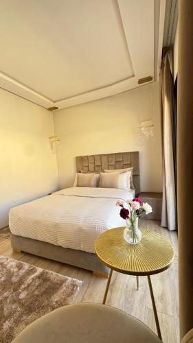a bedroom with a bed and a table with flowers on it at Cozy Studio in Rabat City Center in Rabat