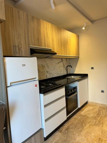 a kitchen with a white refrigerator and a stove at Cozy Studio in Rabat City Center in Rabat