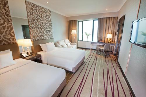 a hotel room with two beds and a television at Dorsett Kuala Lumpur in Kuala Lumpur